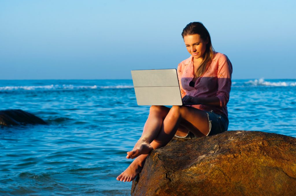 beach-lady by the beach with a laptop
